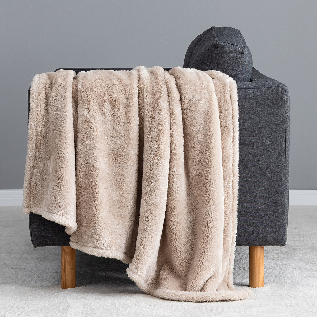 Premium Extra-Fluffy™ Throw in Grain draped over the arm of a gray sofa, close view