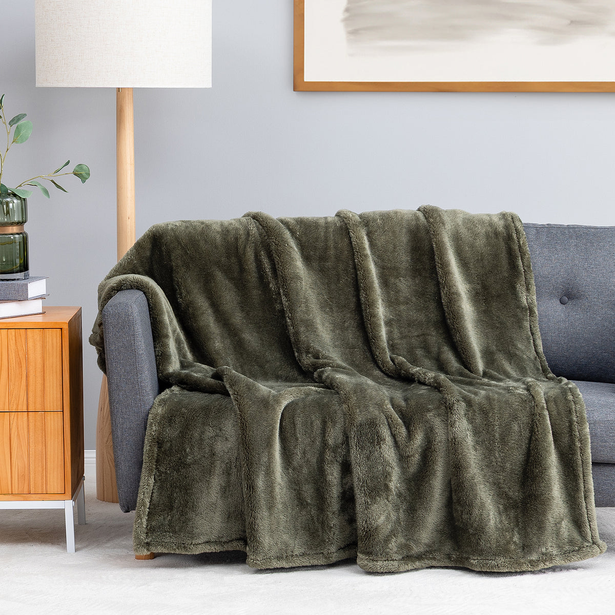 Premium Extra-Fluffy™ Throw in Ivy draped over a gray sofa in a living room