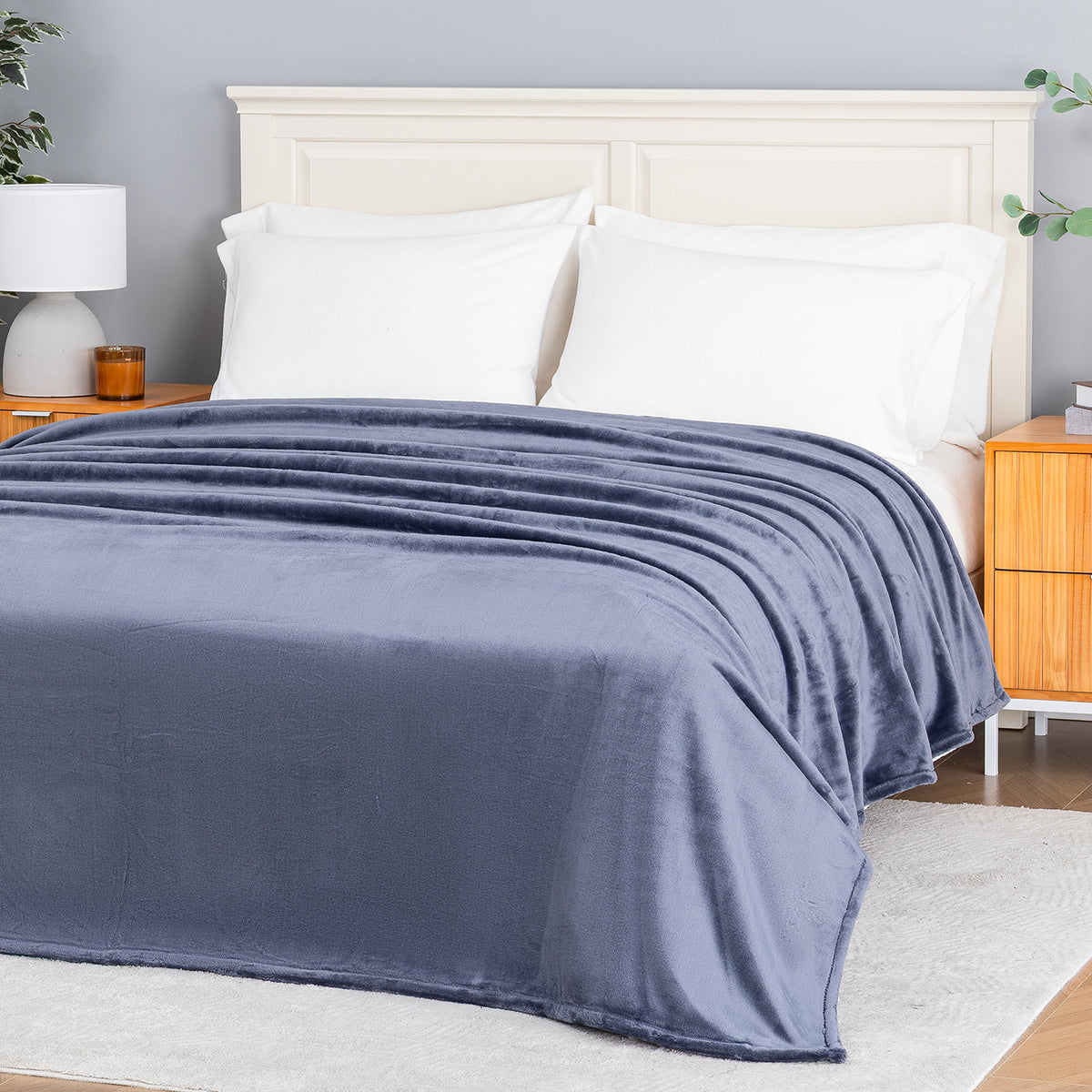 Premium VelvetLoft® Blanket in Galaxy Blue on a made bed, angled view