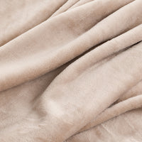 A close-up of draped plush fabric in a soft warm beige or cream tone, showing the texture and folds of the material.