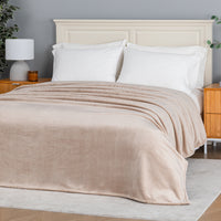 Premium VelvetLoft® Blanket in Hummus on a made bed, angled view