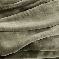 A close-up of draped plush fabric in a muted green color, showing the soft texture and folds of the material.