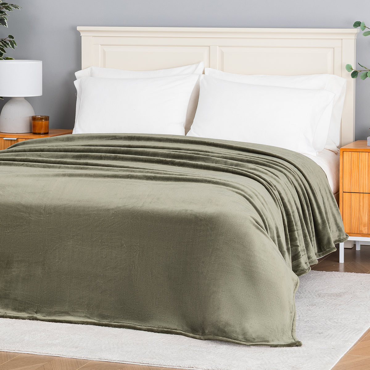 Premium VelvetLoft® Blanket in Ivy on a made bed, angled view