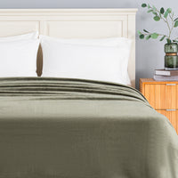 A green Premium VelvetLoft Blanket draped neatly over a bed.