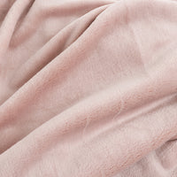 A close-up of draped dusty pink fleece fabric showing its soft, plush texture.