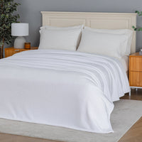 Premium VelvetLoft® Blanket in True White on a made bed, angled view