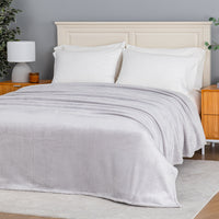 Premium VelvetLoft® Blanket in Wisp Grey on a made bed, angled view