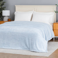 Premium Extra-Fluffy™ Blanket in Arctic Blue spread over a made bed, angled view