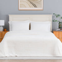 Premium Extra-Fluffy™ Blanket in Cream on a made bed, front view