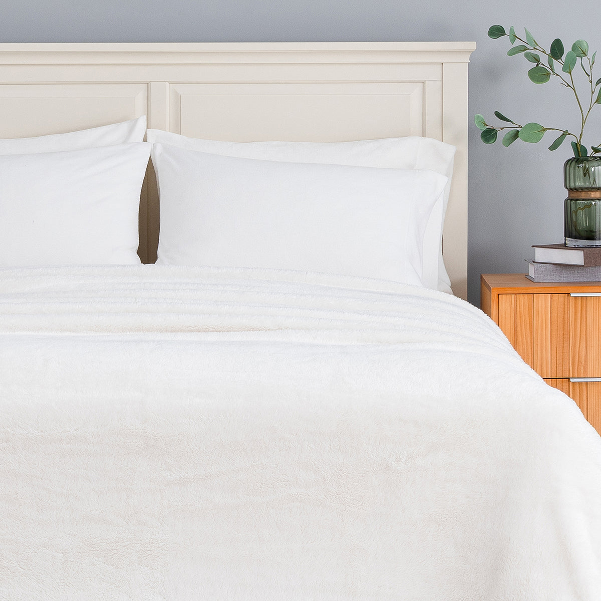 Premium Extra-Fluffy™ Blanket in Cream turned down at the head of a bed, close view