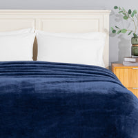Premium Extra-Fluffy™ Blanket in Dress Blue turned down at the head of a bed, close view