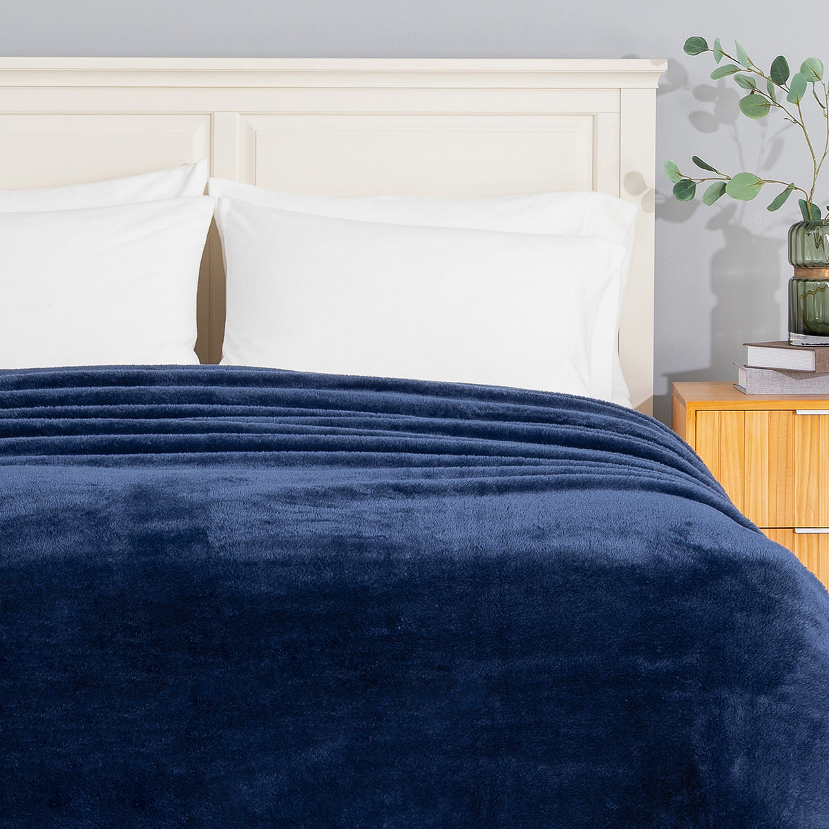 Premium Extra-Fluffy™ Blanket in Dress Blue turned down at the head of a bed, close view