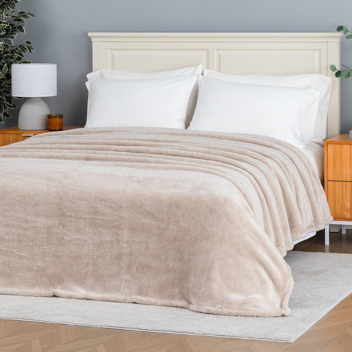 Premium Extra-Fluffy™ Blanket in Grain spread over a made bed, angled view