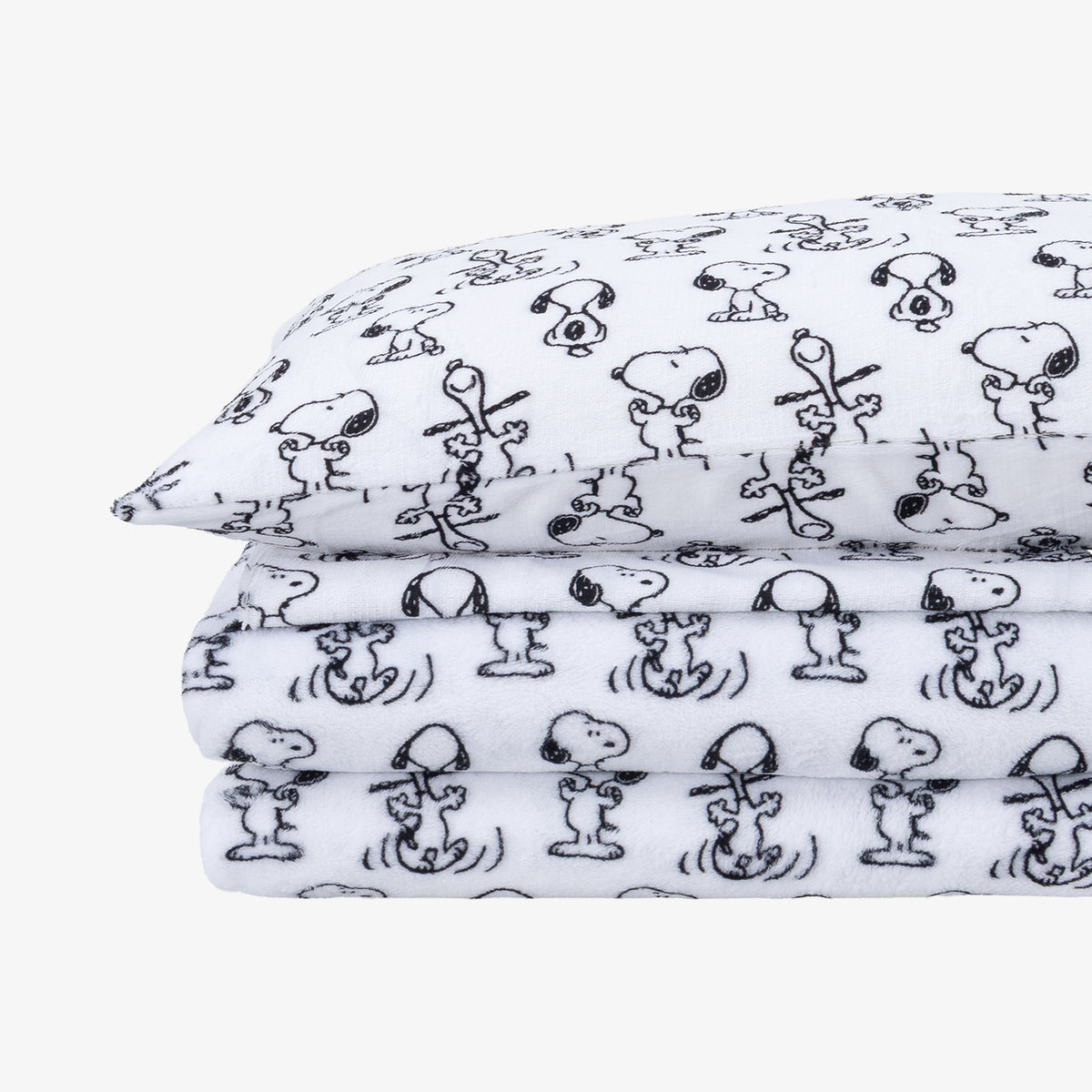 A folded stack of white fabric sheets, printed with a black cartoon character pattern resembling Snoopy and Woodstock.