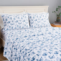 Peanuts white and blue holiday printed VelvetLoft sheet set dressed neatly on a bed.