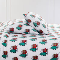 Peanuts holiday printed VelvetLoft sheet set dressed on a bed with two pillows.
