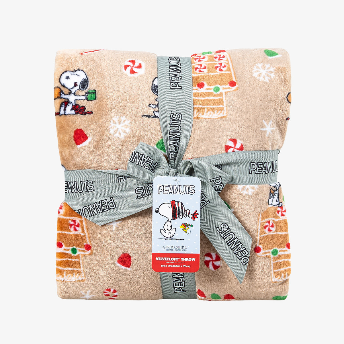 A holiday Peanuts Printed VelvetLoft Throw folded neatly with a ribbon on a white surface.