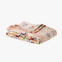 A gingerbread printed holiday Peanuts Printed VelvetLoft Throw folded neatly on a white surface.