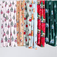 A variety of holiday Peanuts VelvetLoft Throws draped to display their prints.