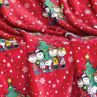Close up of a red holiday Peanuts Printed VelvetLoft Throw.