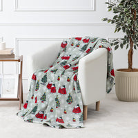 A sage green holiday Peanuts Printed VelvetLoft Throw draped over a white chair.