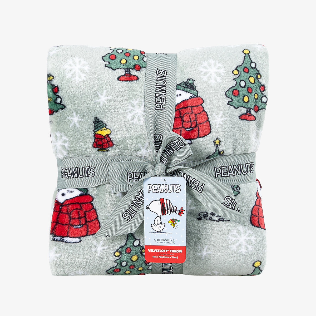 A holiday Peanuts Printed VelvetLoft Throw folded neatly with a ribbon on a white surface.