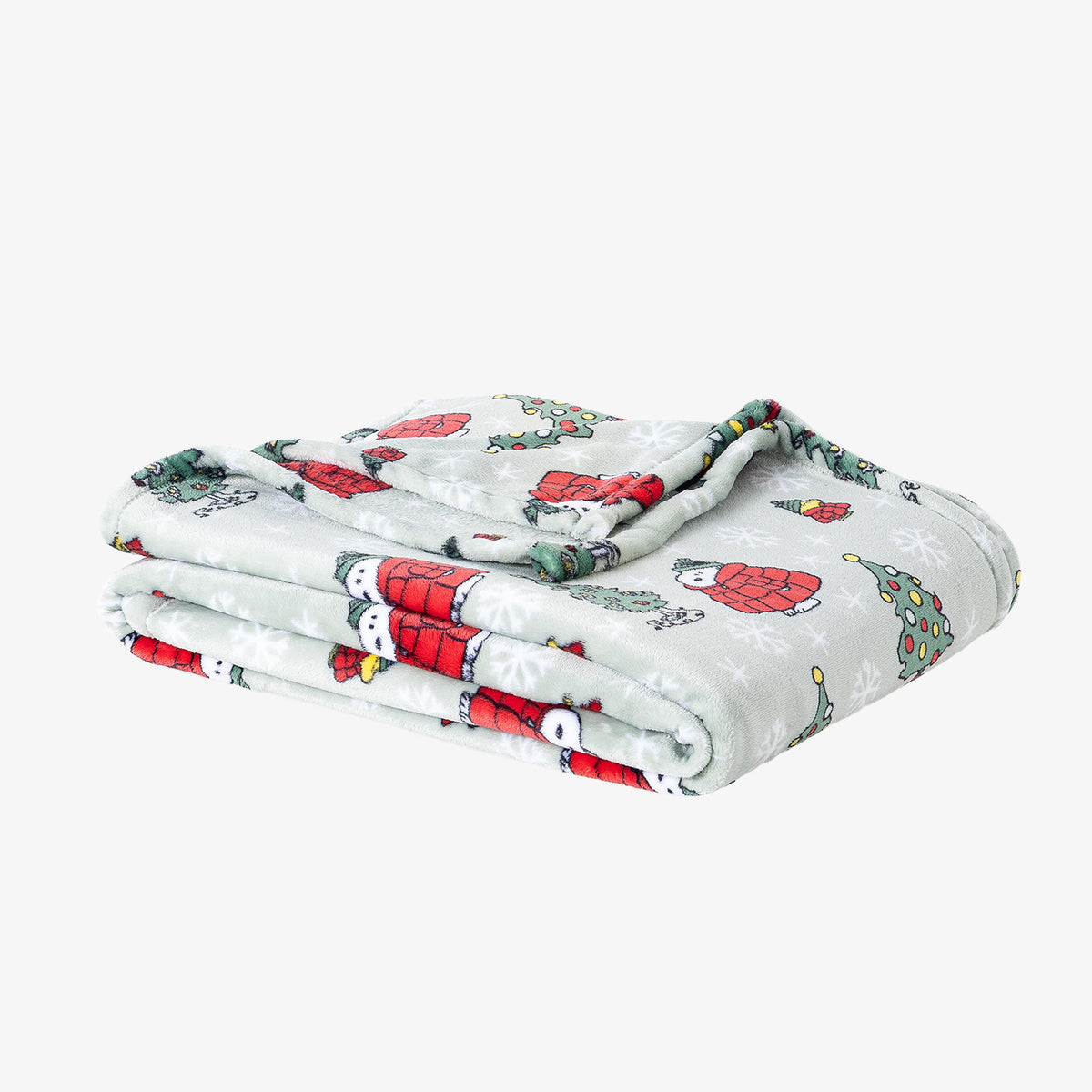 A green holiday Peanuts Printed VelvetLoft Throw folded neatly on a white surface.