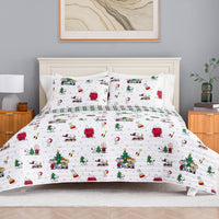 A festive holiday-themed bedding set featuring a white quilt and matching pillow shams printed with cartoon characters like Snoopy and Woodstock in Christmas scenes, styled on a bed in a modern bedroom setting.