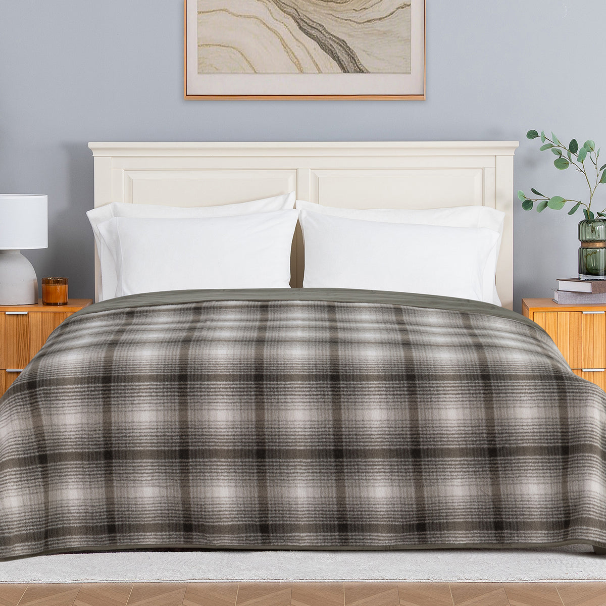 A plaid teddy fleece blanket dressed neatly on a bed in a bright bedroom.