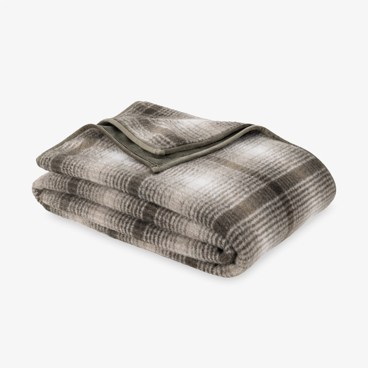 A plaid teddy fleece blanket folded neatly on a white surface.