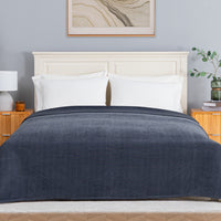 Dusty blue chenille knit blanket dressed neatly on a bed in a bright bedroom.
