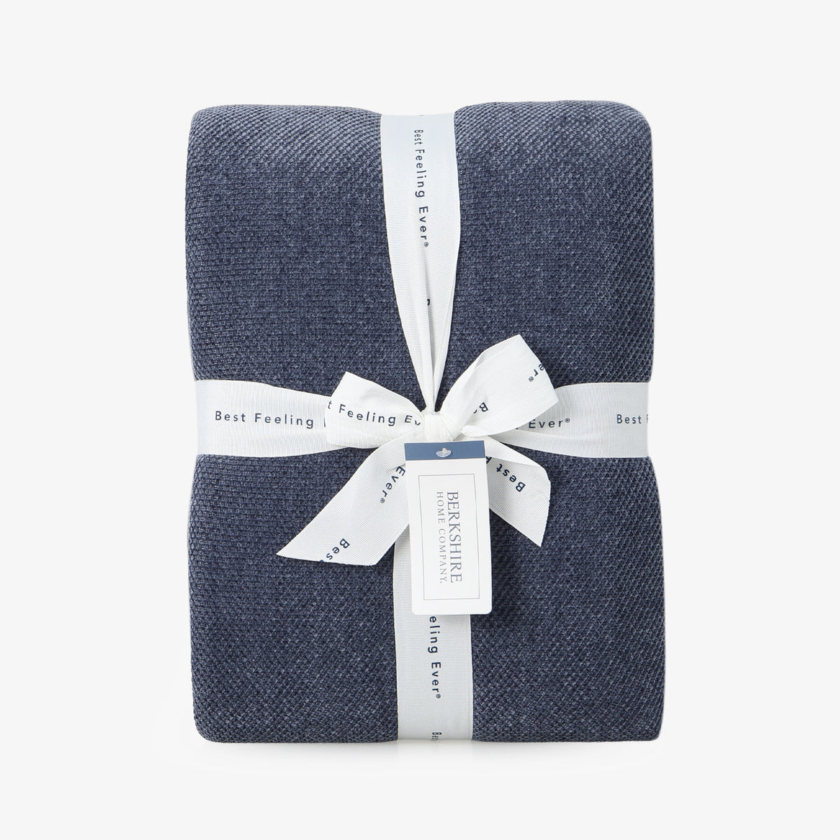 Dusty blue chenille knit blanket folded neatly with a ribbon on a white surface.