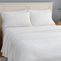 VelvetLoft® Plush Sheet Set in Cream on a made bed, angled view