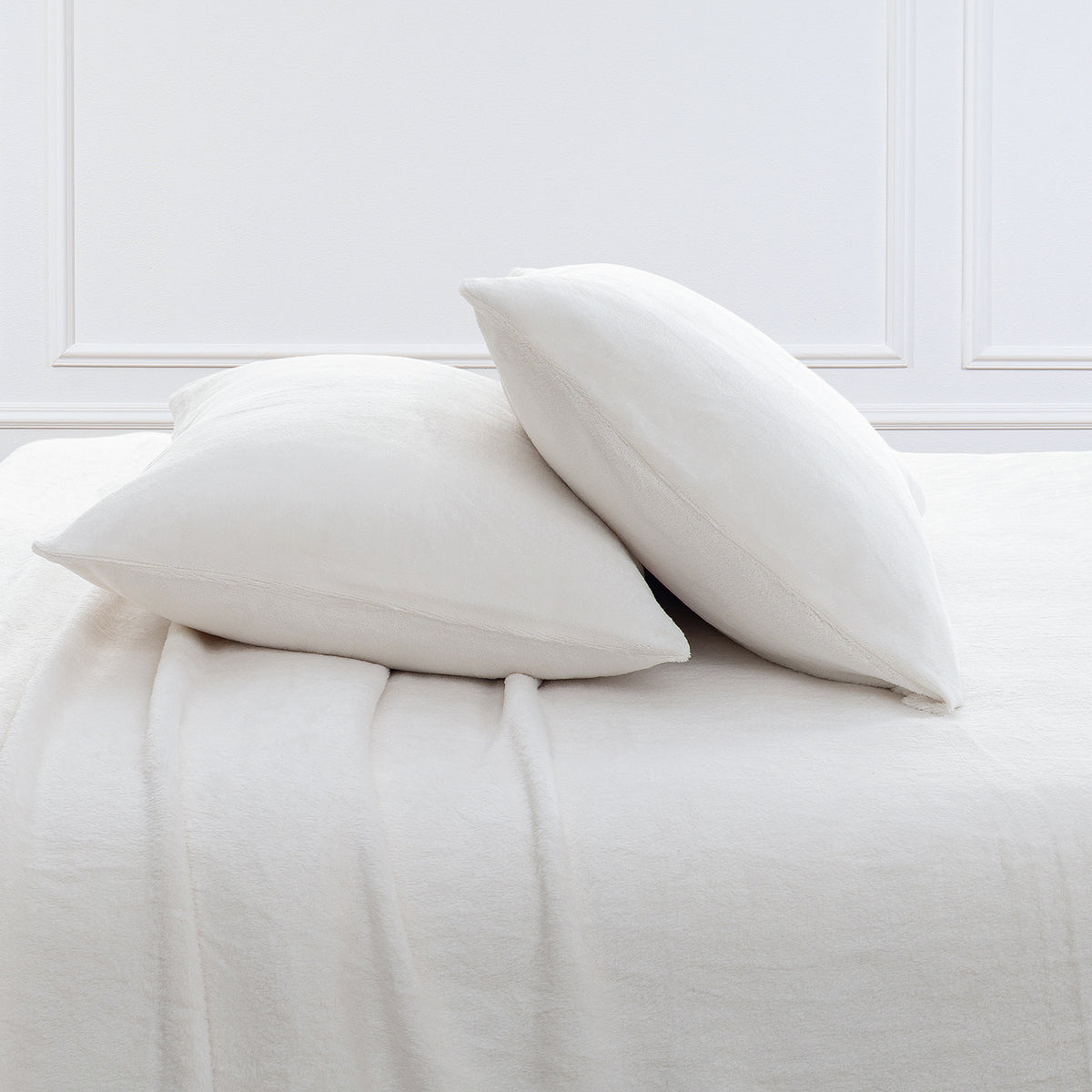 VelvetLoft® Plush Sheet Set pillowcases in Cream on a made bed against a white paneled wall