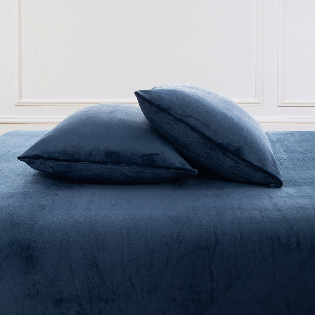 VelvetLoft® Plush Sheet Set pillowcases in Dress Blues on a made bed against a white paneled wall