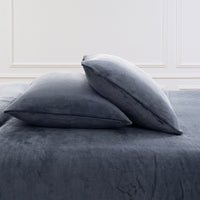 VelvetLoft® Plush Sheet Set pillowcases in Galaxy Blue on a made bed against a white paneled wall