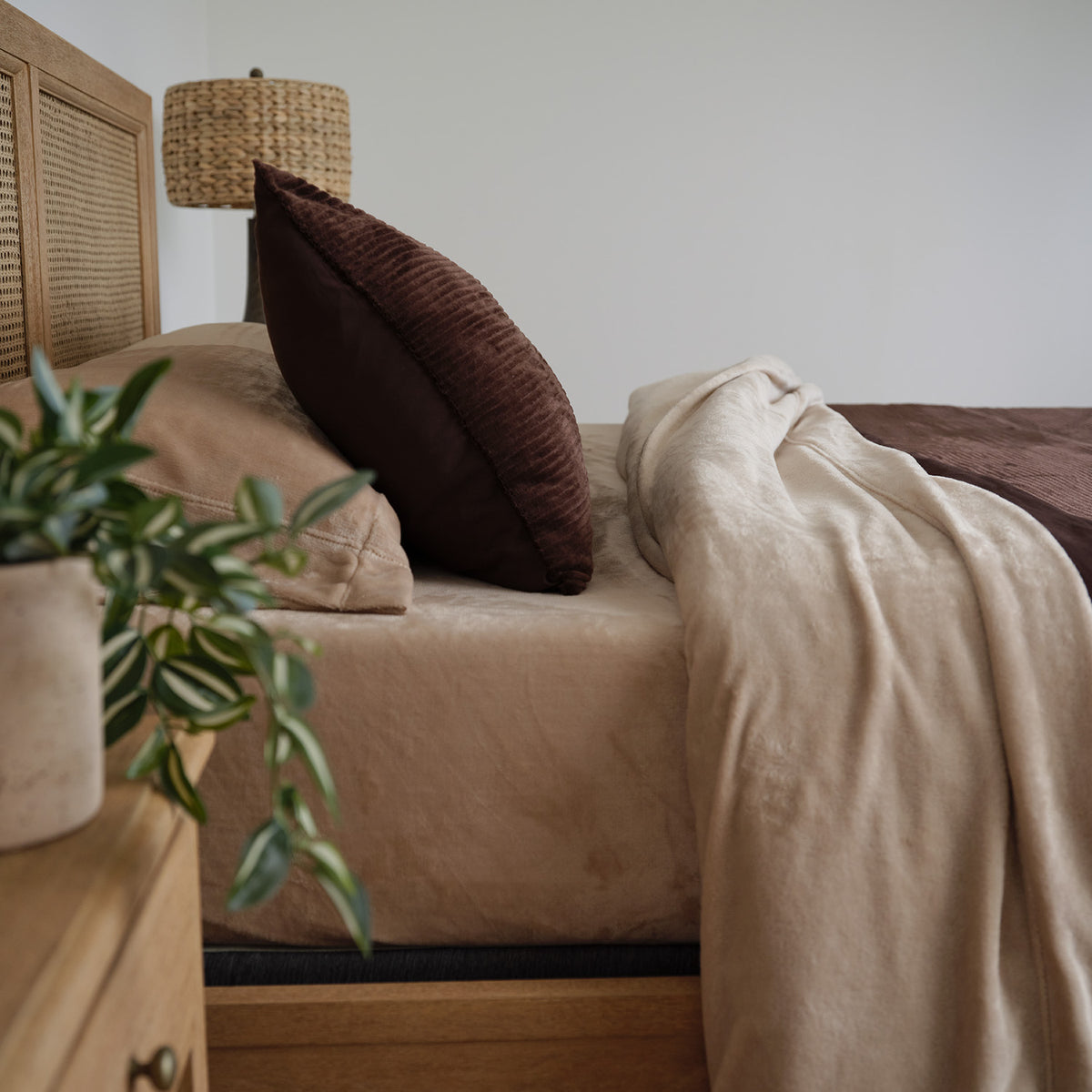 VelvetLoft® Plush Sheet Set in Hummus on a bed with a rattan headboard, side view