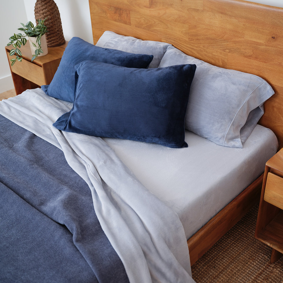 Polar Blue VelvetLoft Sheet Set decorated on a bed with dark blue pillowcases and a dark blue blanket.