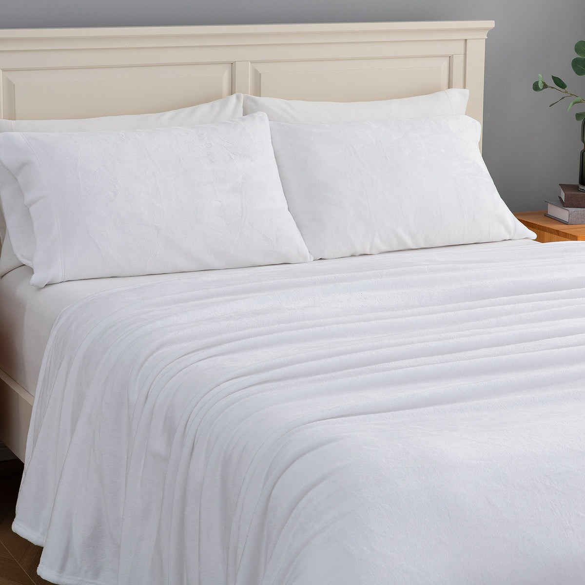 White textured bedding set including a duvet cover and two pillows, neatly arranged on a bed with a light wood headboard.