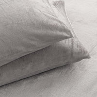Two light gray textured pillows resting on a matching light gray bedspread or blanket.