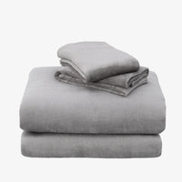 A stack of three folded gray plush blankets or throws on a plain white background.