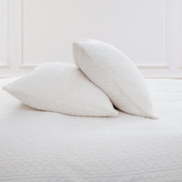 VelvetLoft® Plush Sheet Set pillowcases in Textured Cream on a made bed against a white paneled wall
