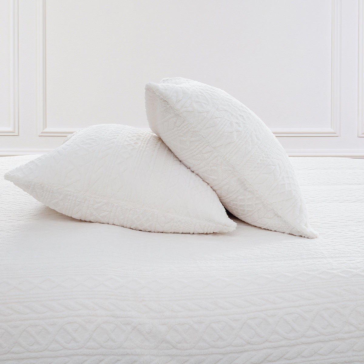 VelvetLoft® Plush Sheet Set pillowcases in Textured Cream on a made bed against a white paneled wall