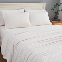 VelvetLoft® Plush Sheet Set in Textured Cream on a made bed, angled view