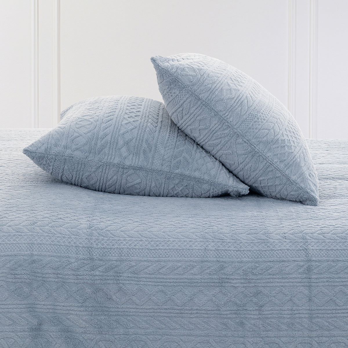 VelvetLoft® Plush Sheet Set pillowcases in Textured Polar Blue on a made bed against a white paneled wall