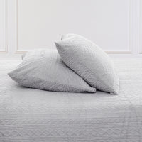 VelvetLoft® Plush Sheet Set pillowcases in Textured Wisp Grey on a made bed against a white paneled wall