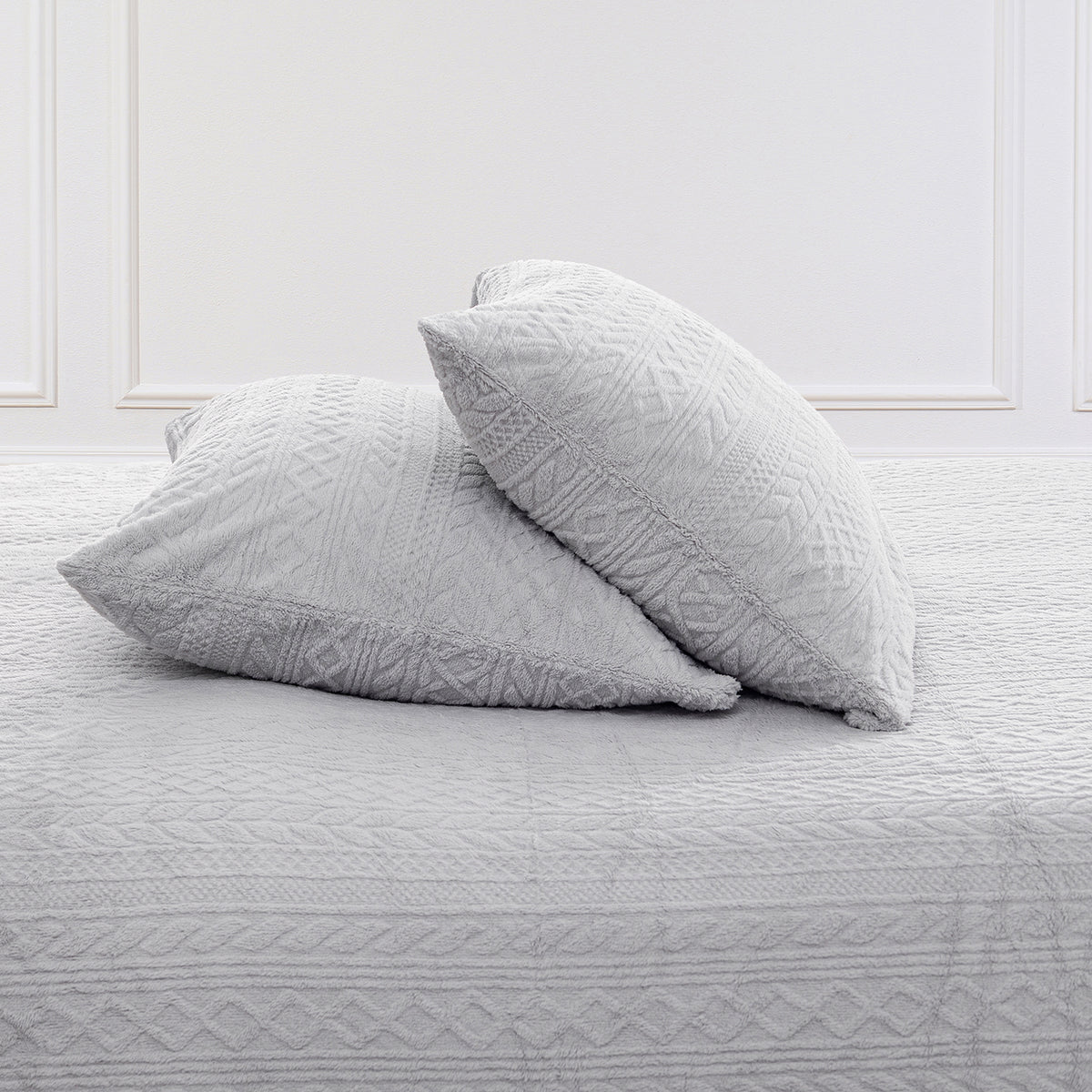 VelvetLoft® Plush Sheet Set pillowcases in Textured Wisp Grey on a made bed against a white paneled wall