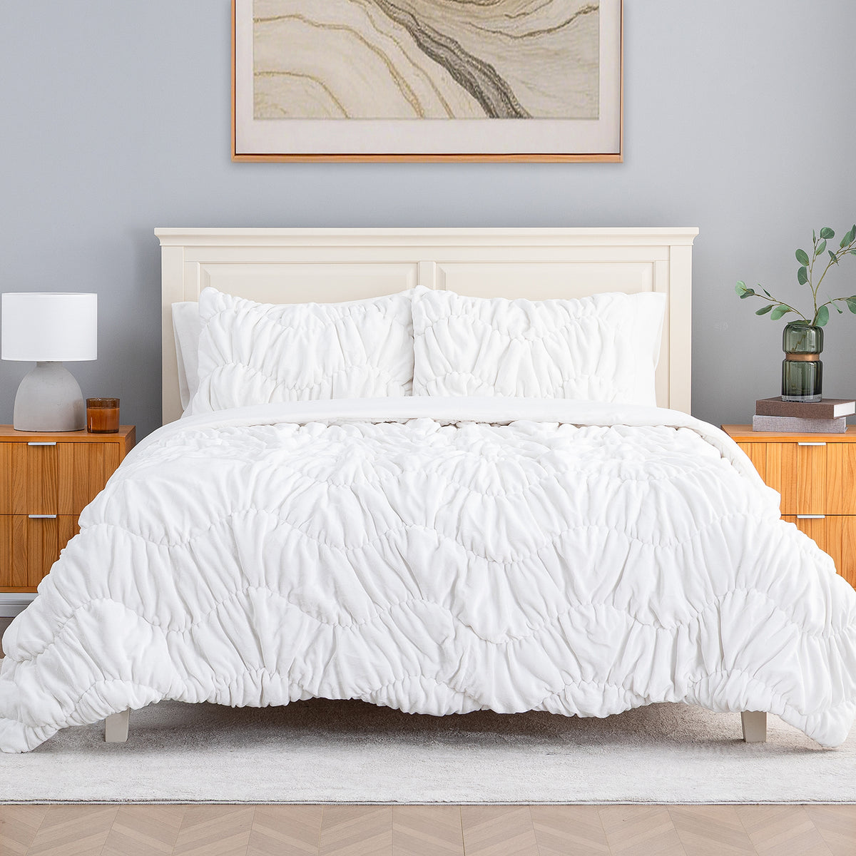 A white ruched VelvetLoft Comforter Set decorated on a bed in a bright room.