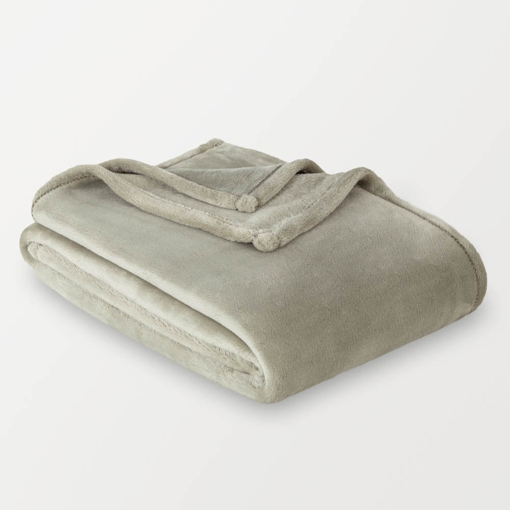 Folded green blanket on a light gray background