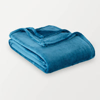 Folded blue blanket on a light gray background